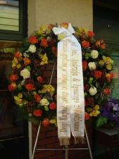 Wieniec pogrzebowy z żywych kwiatów, kształt okrągły średnica ok. 90cm (wieniec rzymski), róże herbaciane i kremowe, storczyki złote (Cymbidium), chryzantema zielona (Santini), zieleń dekoracyjna, szarfa satynowa 10cm (+30 zł).
