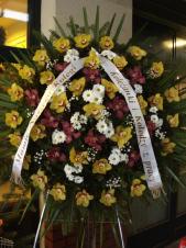 Wieniec z kwiatów żywych w kształcie koła, storczyk złoty i fioletowy (Cymbidium), chryzantema gałązkowa biała (Bacardi), zieleń dekoracyjna, liść palmy, podkład jodłowy, szarfa satynowa szer. 7 cm (+20 zł).