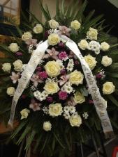 Wieniec pogrzebowy z żywych kwiatów, kształt okrągły, róża kremowa (Avalanche), storczyk jasnoróżowy (Cymbidium), biała chryzantema gałązkowa (Bacardi), tulipan fioletowy, różowy goździk, liść palmy, zieleń dekoracyjna, podkład jodłowy, szarfa satynowa szer. 7 cm (+20 cm).