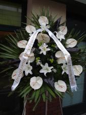 Wieniec pogrzebowy z żywych kwiatów, kształt owalny, anthurium białe (Carnaval), lilie białe, chryzantema zielona (Santini), liście kordyliny, podkład jodłowy, zieleń dekoracyjna, szarfa satynowa 7cm, druk komputerowy (+20 zł).