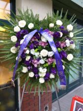 Wieniec pogrzebowy z żywych kwiatów, kształt serca, róże kremowe (Avalanche), eustoma fioletowa, storczyk różowy (Cymbidium), zielona chryzantema gałązkowa (Santini), podkład jodłowy, zieleń dekoracyjna, liść palmowy, szarfa satynowa w kolorze fioletowym szr. 7 cm (+30 zł).