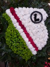 Wieniec pogrzebowy z żywych kwiatów, kształt herb, goździki białe i czarwone, chryzantema zielona (Santini) plumosus, liście paproci, podklad jodłowy