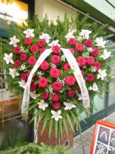 Wieniec pogrzebowy z kwiatów żywych w kształcie serca, storczyk biały (Cymbidium), róża czerwona, podkład jodłowy, zieleń dekoracyjna.