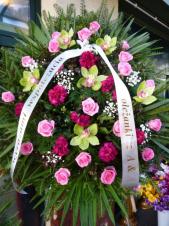 Wieniec jednopłaszczyznowy, róża różowa, storczyk pistacjowy (Cymbidium), tulipany fioletowe, zieleń dekoracyjna, liść palmy, podkład jodłowy, szarfa satynowa 7 cm. (+20zł)