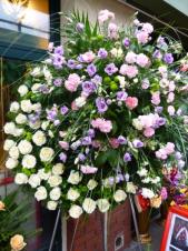 Wieniec nietypowy z kwiatów żywych, wielkość: duży (ok. 1,4 m), eustoma lawendowa, róża kremowa (Avalanche), goździki gałązkowe różowe i kremowe, zielona chryzantema gałązkowa Santini, zieleń dekoracyjna, podkład jodłowy.