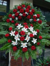 Wieniec z żywych kwiatów, wielkość: duży, róże pąsowe, storczyki białe (Cymbidium), liść palmy, paproć leśna, paproć drzewiasta, podkład jodłowy, zieleń dekoracyjna.