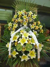 Wieniec z żywych kwiatów, wielkość: bardzo duży, lilie kremowe (Conca D'Or), storczyki złote (Cymbidium), anthurium zielone (Midori), liść palmy, podkład jodłowy, zieleń dekoracyjna, szarfa satynowa 7cm, druk komputerowy.