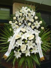 Wieniec pogrzebowy z żywych kwiatów, wielkość: duży, lilie białe (Casablanca), anthurium białe (Presence), róże kremowe (Avalanche), chryzantema zielona (Santini), liść palmy, podkład jodłowy, zieleń dekoracyjna, szarfa satynowa 10cm, druk komputerowy.