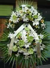Wieniec pogrzebowy z kwiatów żywych, wielkość: bardzo duży, lilie białe (Casablanca), storczyki zielone (Cymbidium), anthurium zielone (Midori), róże białe (Akito), liść palmy, cykas, podkład jodłowy, zieleń dekoracyjna, szarfa satynowa kolor pistacja 10cm, druk komputerowy.