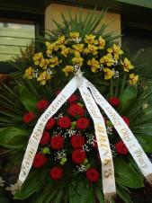 Wieniec z żywych kwiatów, wielkość: duży, róże pąsowe, storczyki złote (Cymbidium), liść palmy, liść kordyliny zielonej, podkład jodłowy, zieleń dekoracyjna, szarfa satynowa 7cm (podwójna) (+30zł)