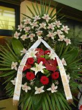 Wieniec z żywych kwiatów, wielkość: duży, storczyki białe (Cymbidium), anthurium bordowe (Tropical Night), róże pąsowe (Red Naomi), santini zielone, liść palmy, liść kordyliny zielonej, podkład jodłowy, zieleń dekoracyjna, szarfa satynowa 7cm druk komputerowy.