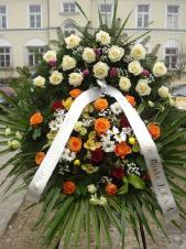 Wieniec z żywych kwiatów, wielkość: średni, róża kremowa (Avalanche), róża herbaciana, tulipan fioletowy, goździk bordowy, storczyk zielony, storczyk złoty, goździk gałązkowy kremowy, zieleń dekoracyjna, liść palmy, podkład jodłowy, szarfa taśma PP szer. 8 cm druk cyfrowy.