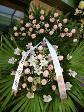Wieniec z żywych kwiatów, wielkość: duży, storczyki białe (Cymbidium), róże różowe, lilie białe, liść palmy, podkład jodłowy, zieleń dekoracyjna, szarfa satynowa biała 7cm. szer.(20zł).