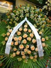 Wieniec z żywych kwiatów, wielkość: bardzo duży, storczyki zielone (Cymbidium), róże łososiowe, liść palmy, podkład jodłowy, szarfa satynowa nadruk złoty szer. 10cm, druk komputerowy (+30zł).