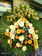 Wieniec z żywych kwiatów, wielkość: bardzo duży, róże herbaciane,  storczyki żółte (Cymbidium), gerbery kremowe i żółte, liść palmy, podkład jodłowy, szarfa satynowa 10cm. szer. w kolorze złotym, druk komputerowy (+40zł).