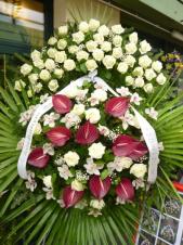 Wieniec z żywych kwiatów, wielkość: bardzo duży, róże białe,  storczyki białe (Cymbidium), anthurium bordowe, liść palmy, podkład jodłowy, szarfa satynowa 10cm. szer., druk komputerowy (+30zł).