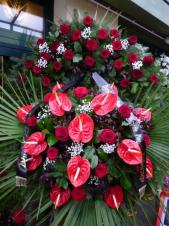 Wieniec pogrzebowy z żywych kwiatów, wielkość: duży, róże pąsowe, anthurium czerwone, liść palmy, podkład jodłowy, zieleń dekoracyjna, szarfa czarna satynowa 7 cm. (+30zł)