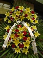 Wieniec z żywych kwiatów, lilia kremowa, róża czerwona, storczyk złoty (Cymbidium), chryzantema zielona (Santini), podkład jodłowy, zieleń dekoracyjna, liść plamy.