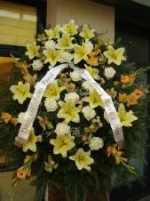 Wieniec z żywych kwiatów, lilia kremowa, róża kremowa, mieczyk herbaciany, storczyk zielony (Cymbidium), podkład jodłowy, zieleń dekoracyjna.